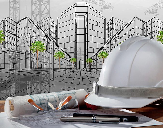 A white construction helmet with blueprints and pencils on a table in front of a cityscape drawing.