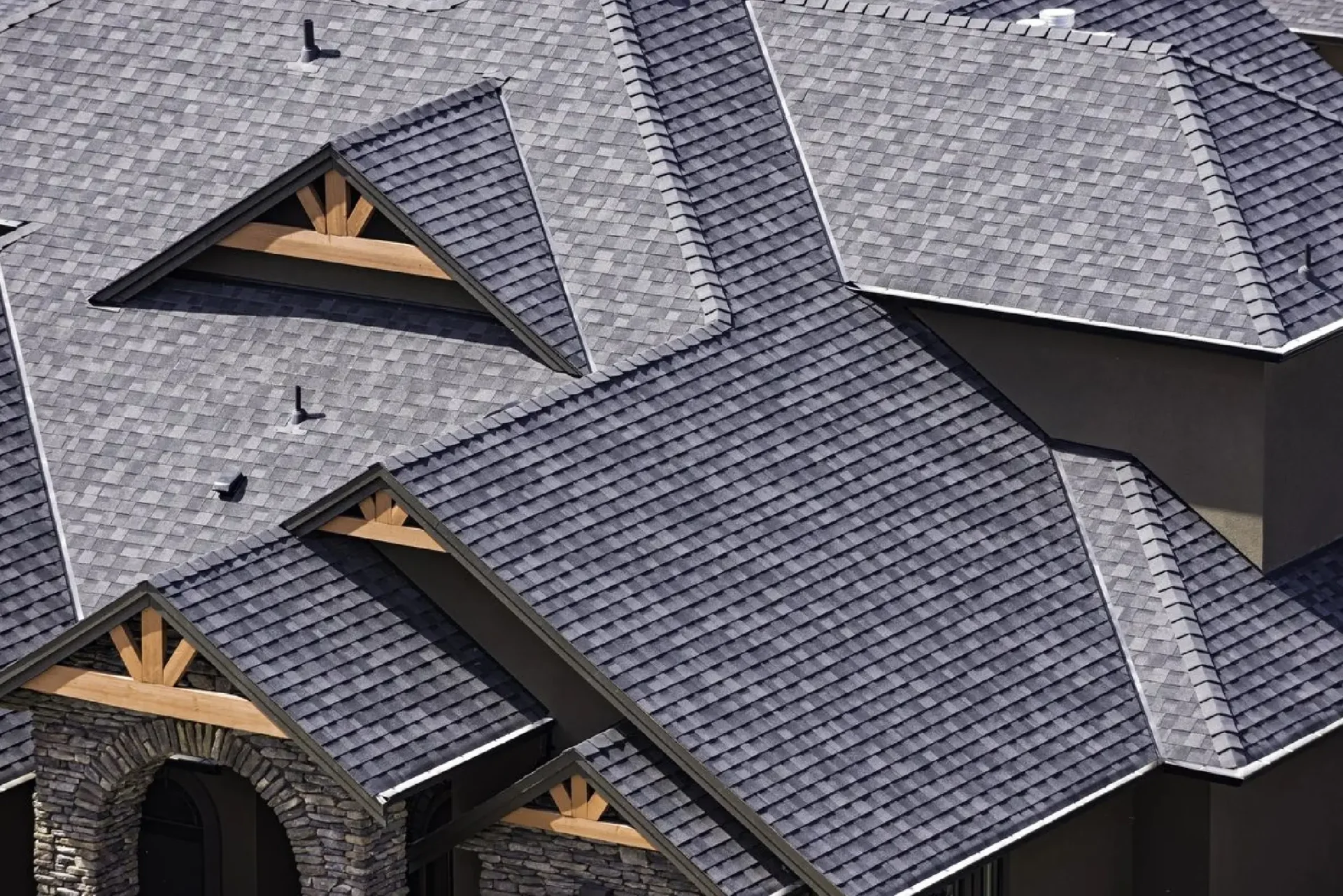 Aerial view of intersecting rooftops with gray shingles.